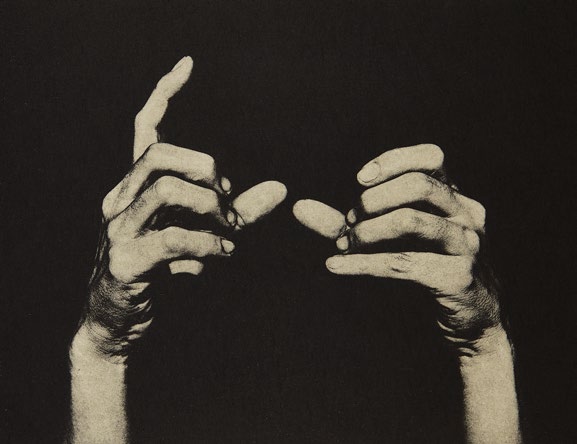 Two hands against a black background.